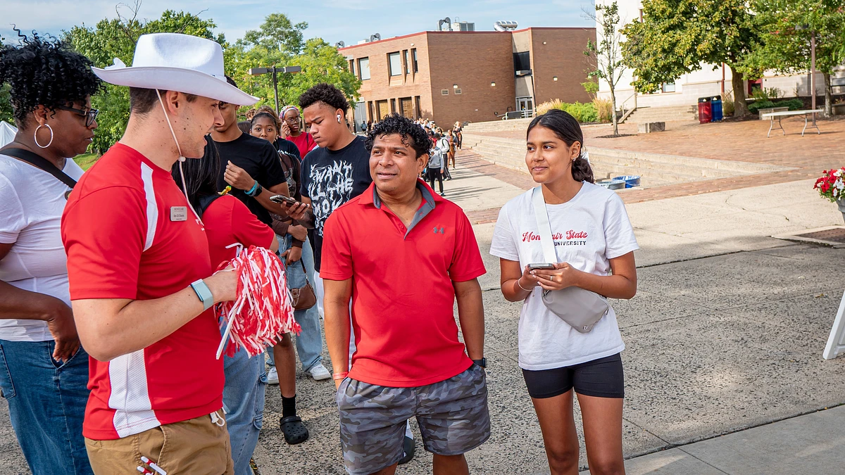 Student, parent, and orientation leader talking.